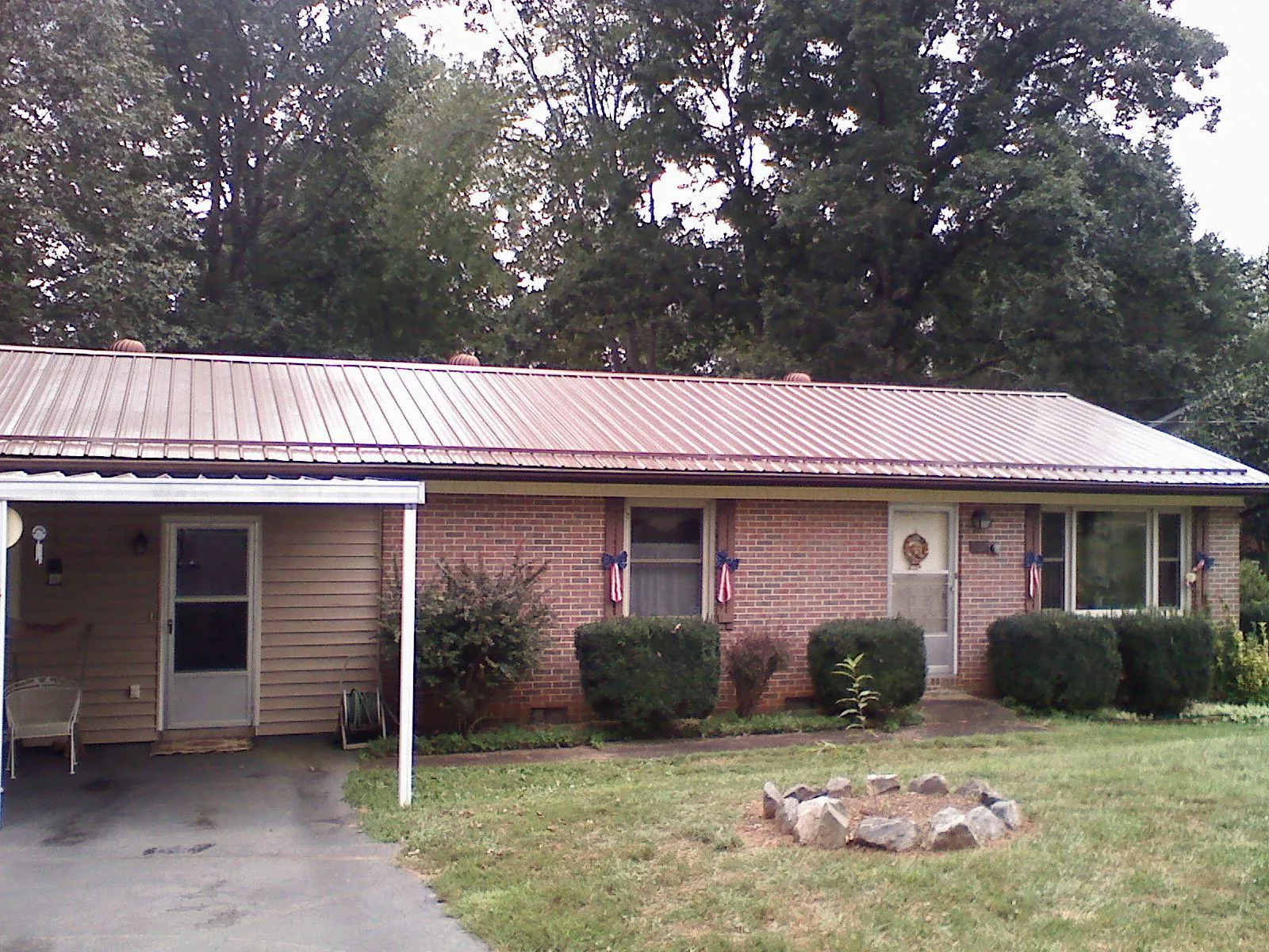 Bronze metal roof and carport on a brick ranch home — Roof Repair work by our crew in Gardners